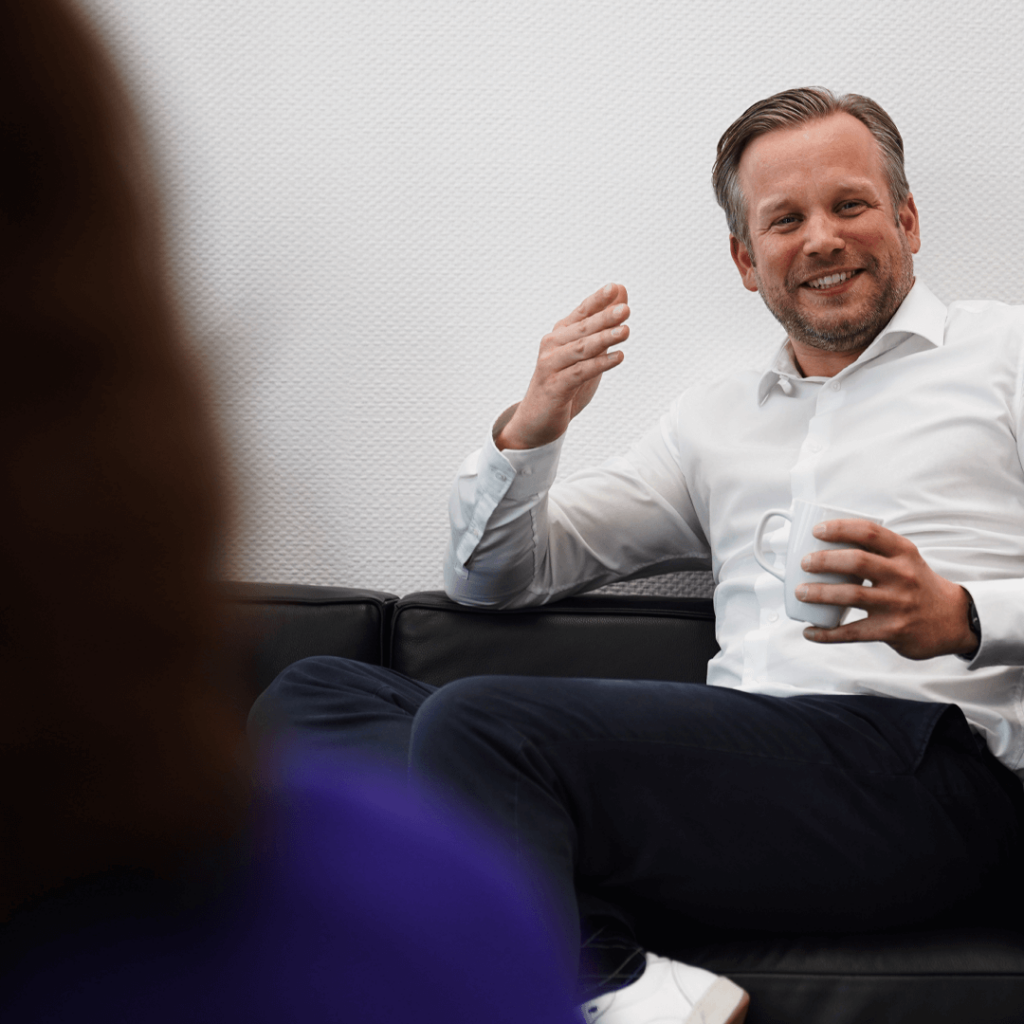 Partner Sebastian Löhr mit Kaffeetasse im Beratungsgespräch