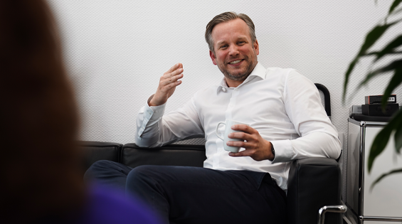 Partner Sebastian Löhr mit Kaffeetasse im Beratungsgespräch